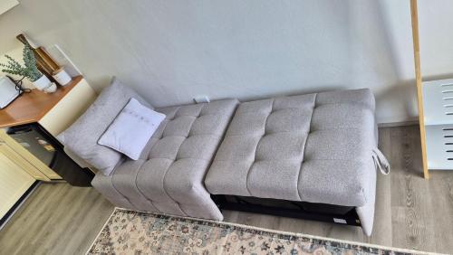 a gray couch in a room with a rug at Kiama Dreams in Kiama