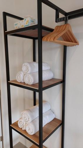 a shelf filled with towels in a bathroom at Bukettree homestay satun in Ban Khok