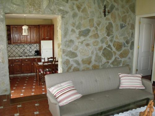 sala de estar con sofá y pared de piedra en La Orotava-casa Rural Los Nardos, en Montijos