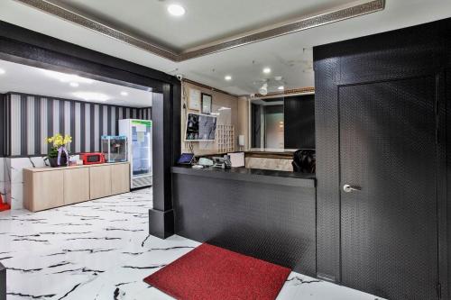 仁川にあるJuan 3&4 Hotelの赤い敷物が敷かれたキッチンに通じるドア