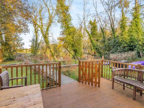 een houten terras met twee banken erop bij Lion House- Uk45705 in Brinkley