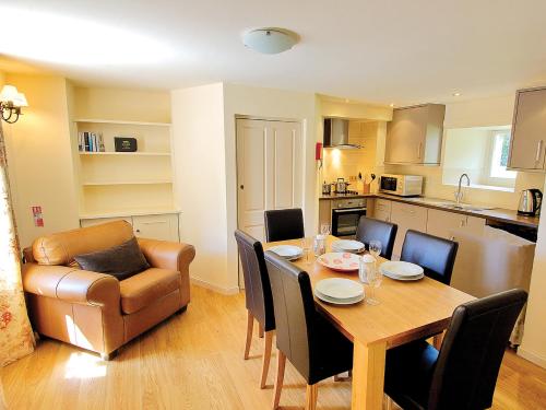 cocina y comedor con mesa y sofá en The Clock House, en Smailholm
