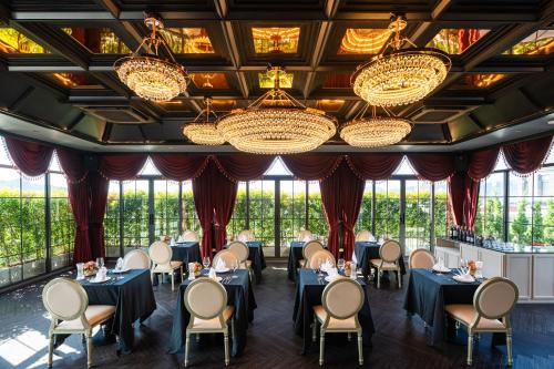 a dining room with tables and chairs and chandeliers at Chateau Du Village Patong in Patong Beach