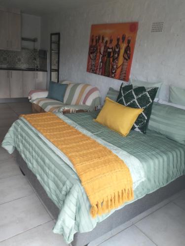 a large bed with colorful pillows and a couch at Mountain view in George