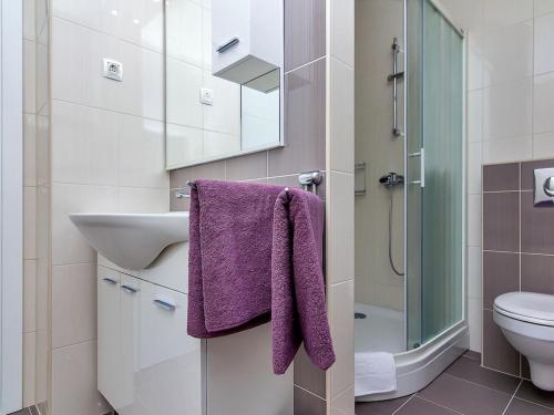 a bathroom with a sink and a purple towel at Maslina with heated pool in Veliko Brdo
