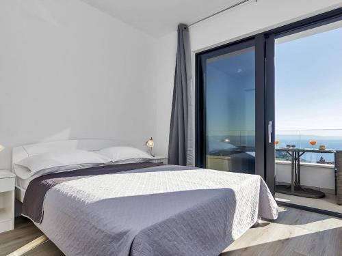 a bedroom with a bed and a large window at Maslina with heated pool in Veliko Brdo