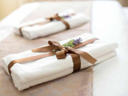 twee witte handdoeken met een strik op een tafel bij Zara with heated hydromassage pool in Jasena Majići