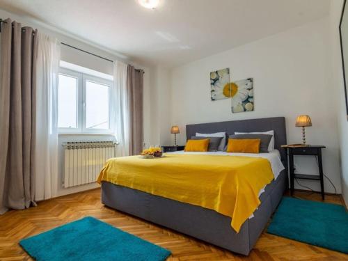 a bedroom with a large yellow bed with blue rugs at Villa Mia with pool in Aračići
