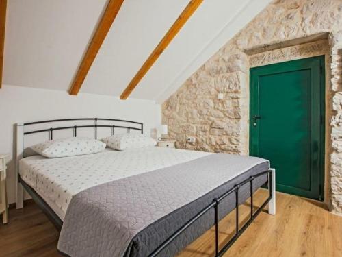 a bedroom with a bed with a green door at Buljanovi Dvori with private pool in Garci