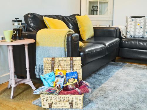 AshwaterにあるMeadowside Forgeのソファの横の床に置かれた食べ物の入ったバスケット