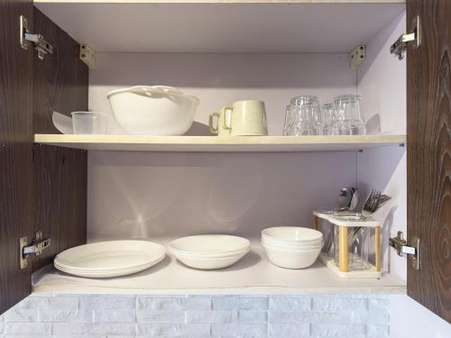 a pantry with plates and bowls on shelves at Destiny Hotel - 1605 in Sampong