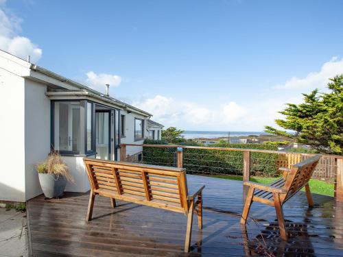 una terraza de madera con un banco y una casa en Semybadazee, en Poundstock
