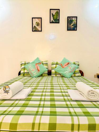 a bedroom with a green and white bed with pillows at Felicitas Guest House- Siargao in General Luna