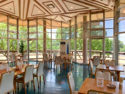 a restaurant with tables and chairs and windows at 芸西村の家 in Geisei