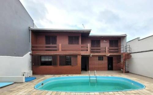 a building with a swimming pool in front of a building at Casas em frente ao mar com piscina, churrasqueira in Pontal do Paraná