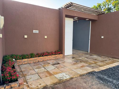 a house with a garage and flowers in front of it at Casa Paradise in Jijoca de Jericoacoara