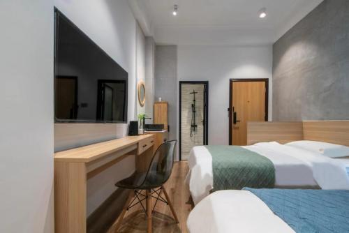 a hotel room with two beds and a desk at Sheng Hai Yun Ju in Zhuhai