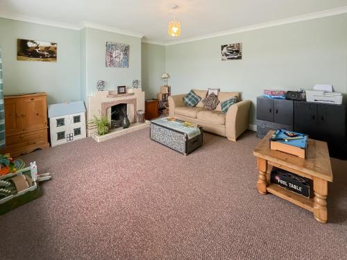 Una sala de estar con un sofá y una chimenea. en Homestead, en Long Sutton
