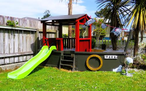 ein kleiner Spielplatz mit Rutsche im Hof in der Unterkunft CROOKED MILE COTTAGE - BY THE SEA - family friendly in Hokitika