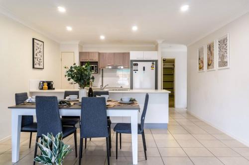 a kitchen and dining room with a white table and chairs at Bright & Cozy 2BR Duplex near Logan Central Comforts in Marsden