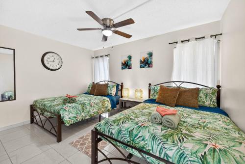 een slaapkamer met twee bedden en een plafondventilator bij The Flamingo*4bed*pool*jacuzzi*foosball in Valrico