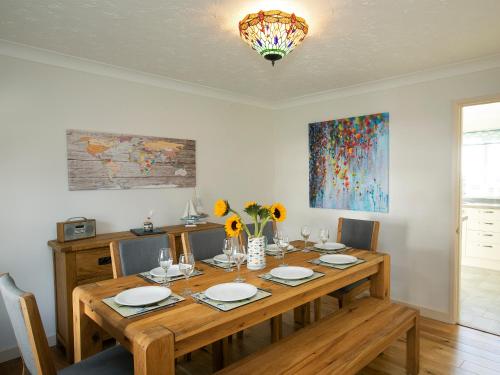 a dining room with a wooden table with chairs at Headlands House - Uk6739 in Lydstep