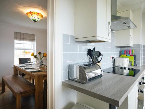 a kitchen with a counter with a microwave and a table at Headlands House - Uk6739 in Lydstep