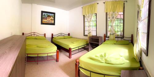 ein Zimmer mit zwei Betten und einem Tisch und Fenstern in der Unterkunft Villa Clara Casa Campestre, Piscina, Naturaleza, Paseo de Río in Melgar