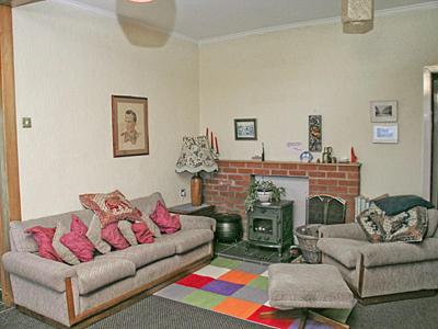 a living room with two couches and a fireplace at Braemar in Lendalfoot