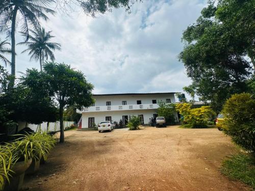 a white building with cars parked in front of it at Viyan hotel in Negombo