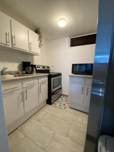 a kitchen with white cabinets and a stove top oven at Condado Serenity by the Sea in San Juan