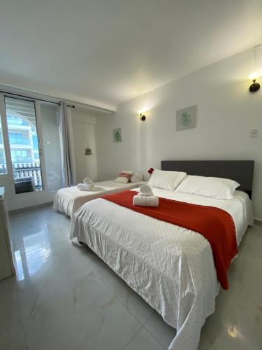 two beds in a white room with a large window at Condado Serenity by the Sea in San Juan
