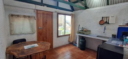 a room with a table and a window and a door at Cabañas Don Jorge - Cabaña Fragata in Puerto Baquerizo Moreno
