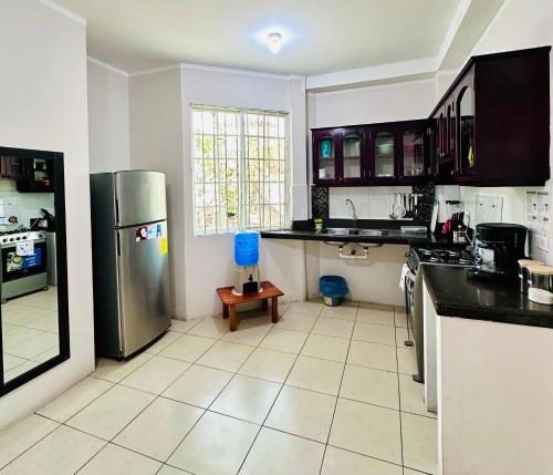 a kitchen with a stainless steel refrigerator and a tile floor at León Dormido Suite 01 in Puerto Baquerizo Moreno