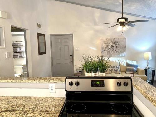 a kitchen with a stove and a living room at 1BD condo DFW South I10 in Sowers