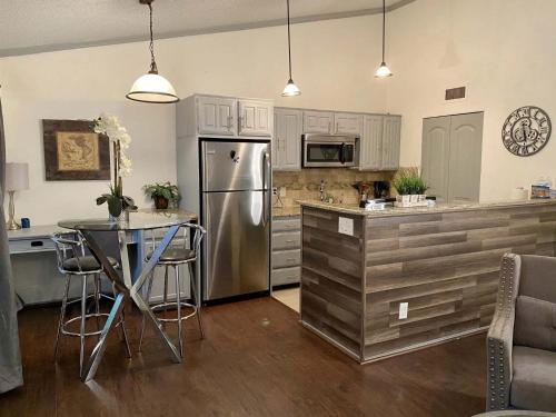 a kitchen with a stainless steel refrigerator and a table at 1BD condo DFW South I10 in Sowers
