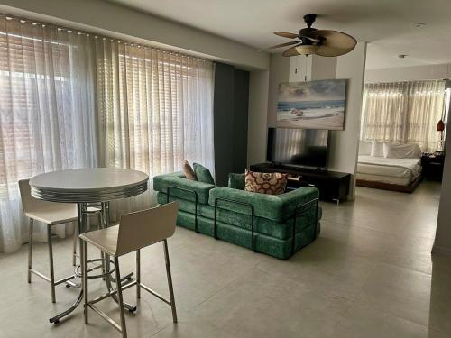 Una sala de estar con un sofá verde y una mesa. en South Point Cozy Apartment, en Miami Beach