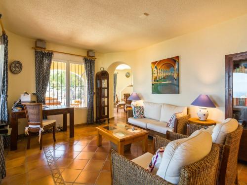 una sala de estar con un sofá y sillas en Villa with Sea Breeze Charm, en Cumbre del Sol