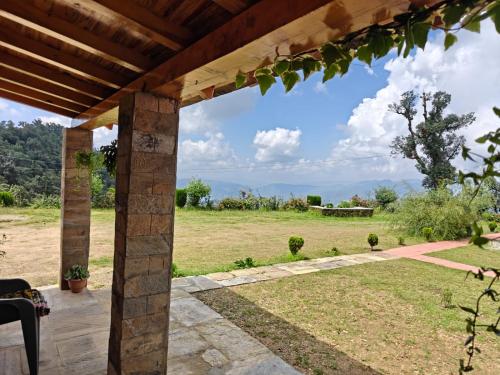 a view from the porch of a house with a view of a field at Buransh Retreat in Jageshwar