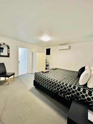 a hotel room with a bed and a chair at Twin Swans Motel in Inverell