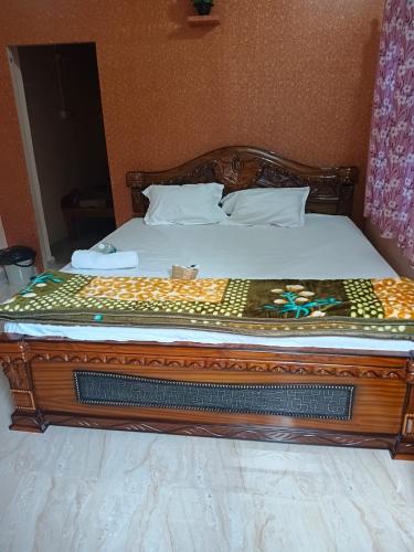a bed in a room with a wooden frame at Manvitha Homestay in New Hampi
