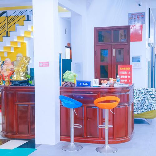 a bar with two stools in a room with stairs at Bảo Di Sóc Trăng Hotel in Soc Trang