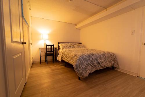 een kleine slaapkamer met een bed en een tafel bij Bright & Spacious 2 Bedroom Apartment Free Wi-Fi, Free Parking, Near Nature Trails in Toronto