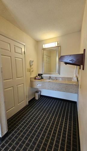 a bathroom with a sink and a large mirror at Americas Best Value Inn Mount Vernon in Mount Vernon