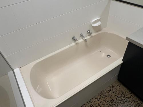 Una gran bañera blanca en un baño. en Central Comfort, en Shepparton