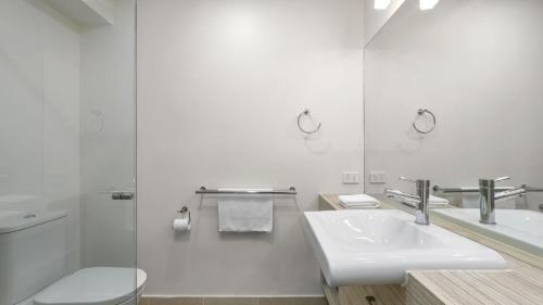 アポロ・ベイにあるTriplet Apollo Bayの洗面台とトイレを備えた白いバスルーム