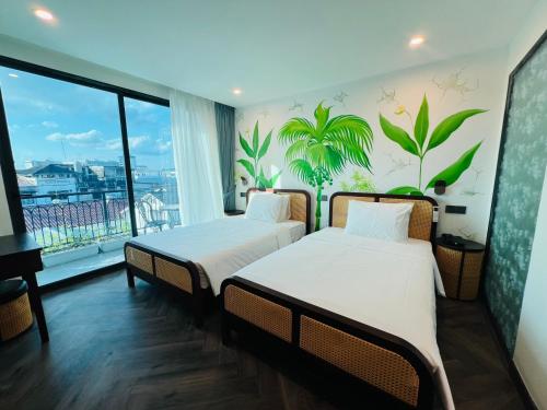 two beds in a room with a view of the city at The Green Hotel Vientiane in Vientiane