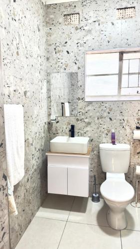 a bathroom with a white toilet and a sink at Seaside Studio 22 in East London