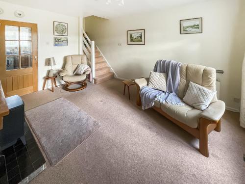 a living room with a couch and two chairs at Pipit Cottage in Burnsall