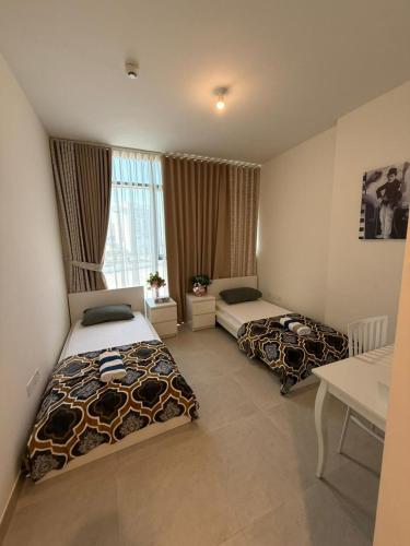 a hotel room with two beds and a window at Luxury 2-Bedroom APT - Sea Views in Saadiyat Island in Abu Dhabi